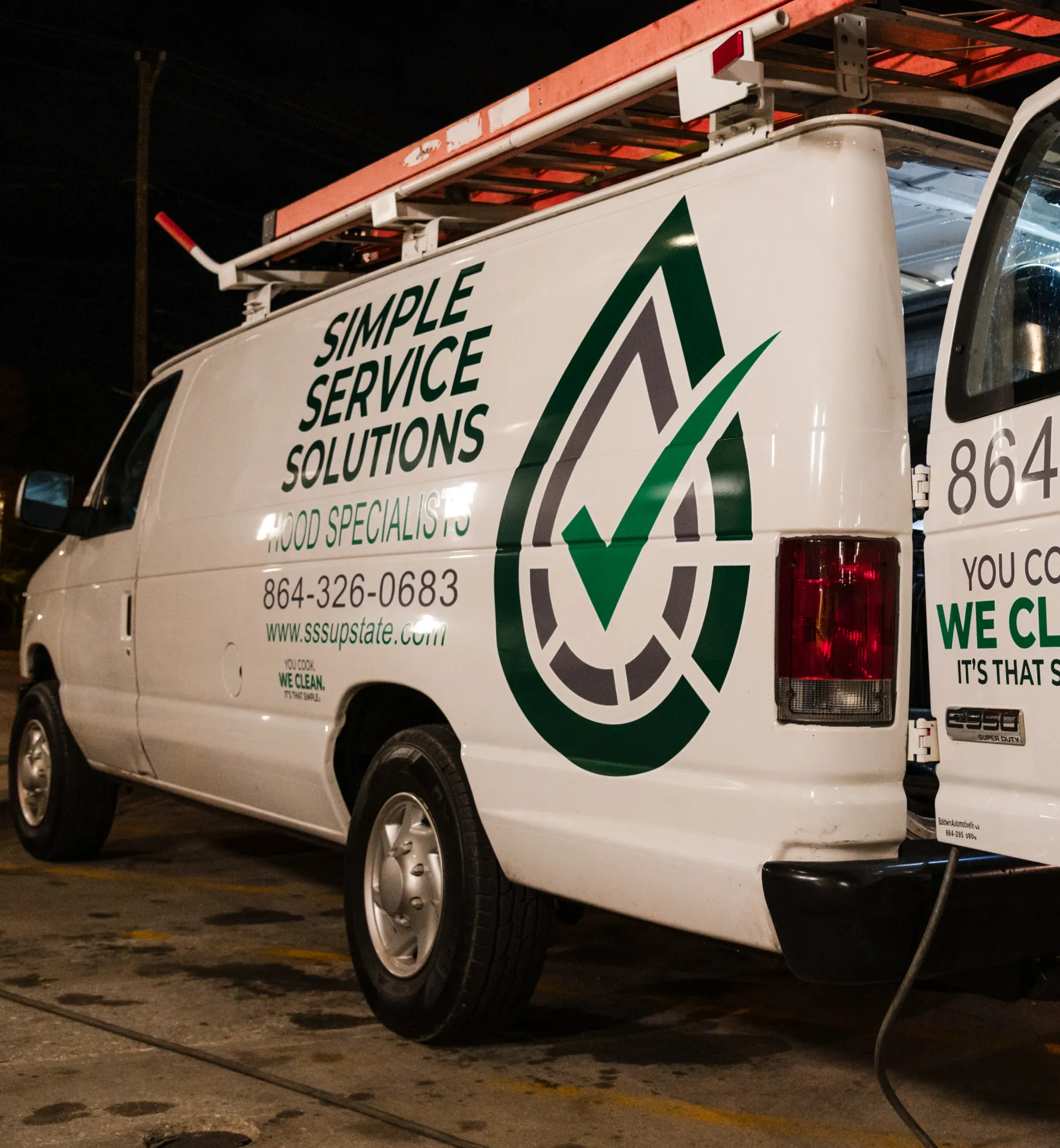 White service van with "Simple Service Solutions" logo and contact details parked at night.